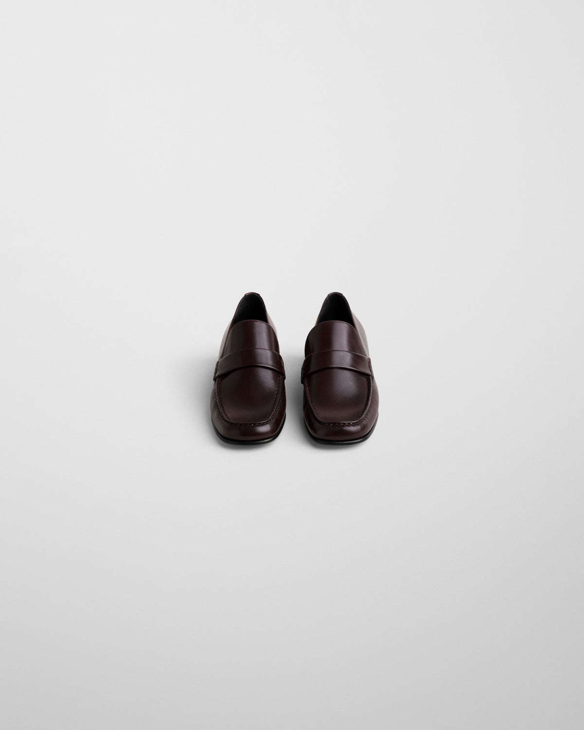 Phoebe Philo loafers oxblood leer vooraanzicht, symmetrisch paar, glad bovenwerk en gestructureerde wreefband