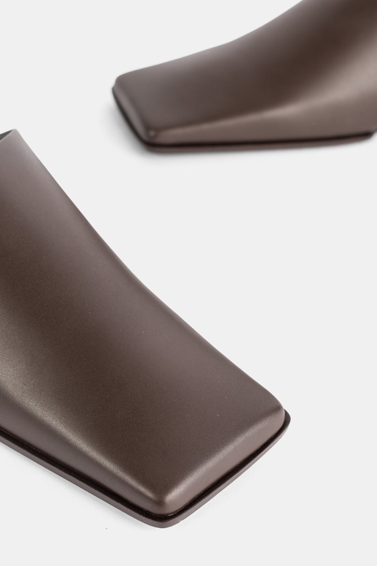 Maison Alaïa gros plan embout carré rembourré slipper cuir chocolat brillant, finition laquée noire