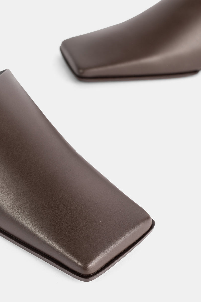 Maison Alaïa gros plan embout carré rembourré slipper cuir chocolat brillant, finition laquée noire
