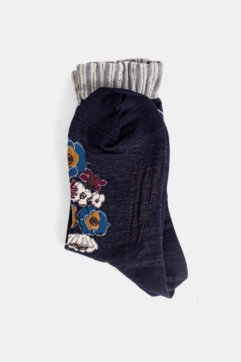 Antipast chaussettes en maille marine pliées, broderies florales bleues, ocres et bordeaux sur le devant
