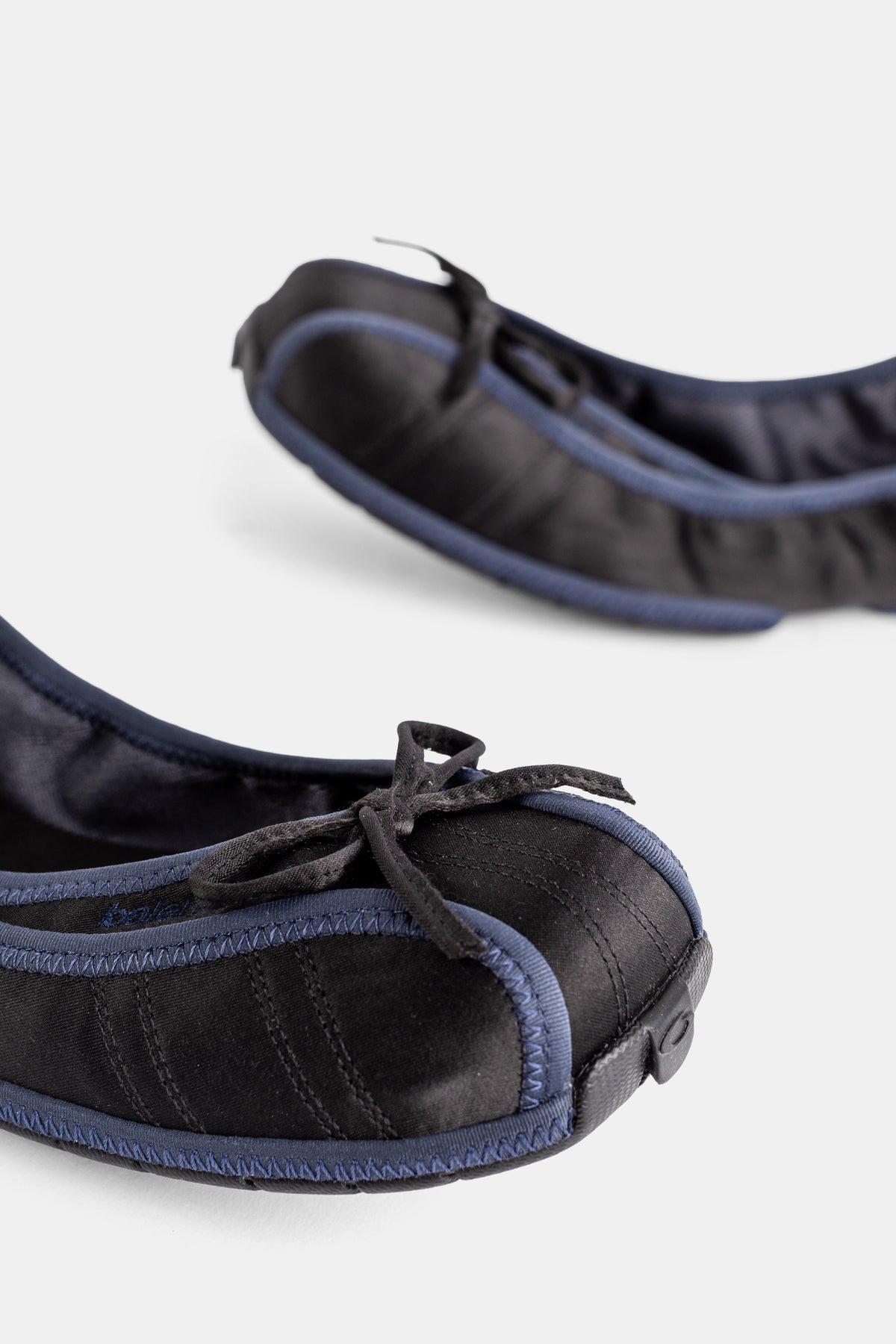 Balenciaga ballerines noires gros plan embout arrondi nœud ruban et surpiqûres liseré bleu marine contrasté