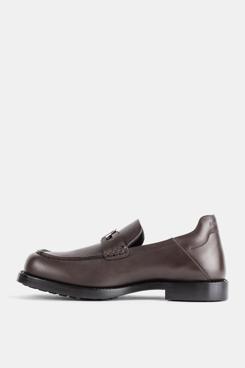 Balenciaga Comfy Mokassin im Seitenprofil, schokoladenbraunes Glattleder, Riemen und strukturierter schwarzer Absatz.