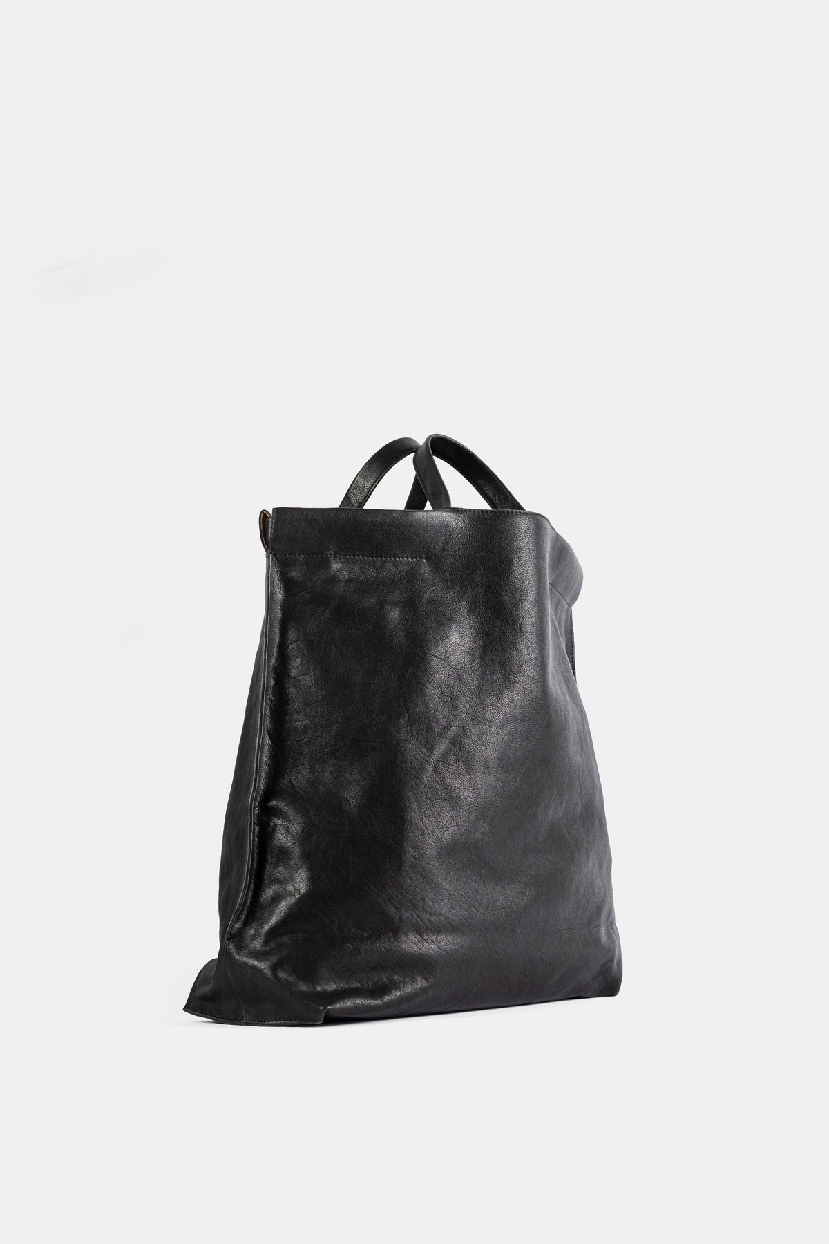 Bea Mombaers Shopper L cuir noir vue trois quarts, base évasée et anses entrelacées en cuir lisse