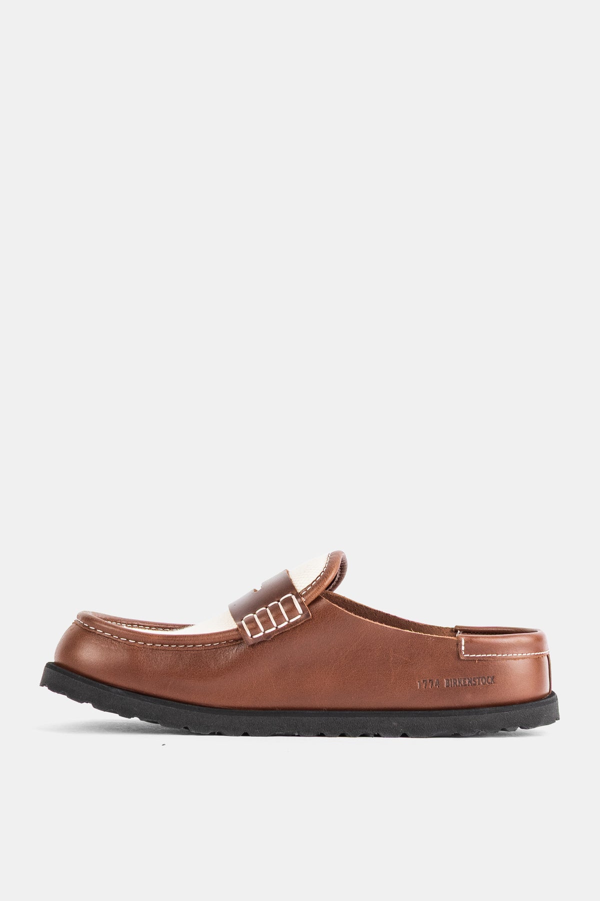 Birkenstock 1774 Naples damesmule in zijprofiel van glad kaneelbruin leer met crèmekleurige pennyband.