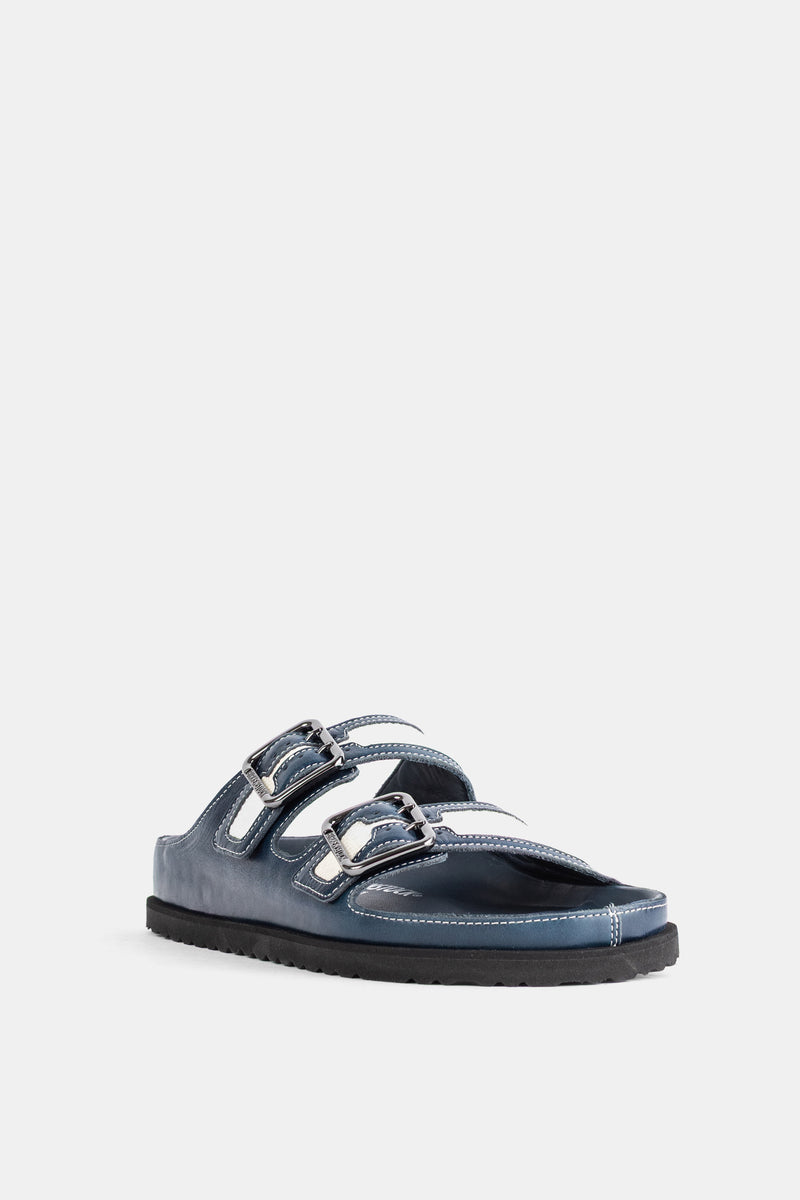 Sandalo piatto uomo Birkenstock 1774 in pelle blu marina con tre cinturini a fibbia e suola nera dentellata