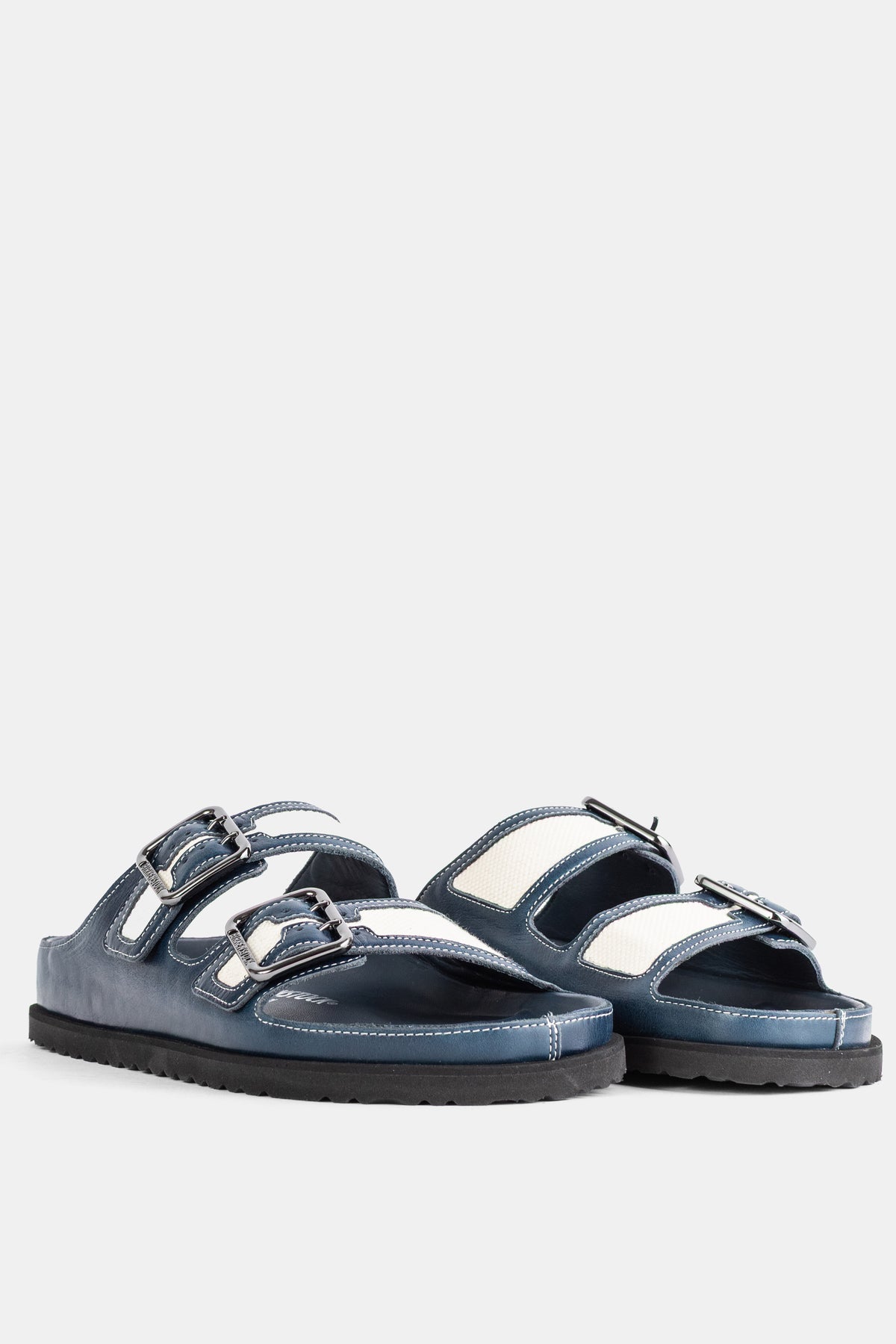 Birkenstock 1774 Arizona Midnight vista a tre quarti, tallone in pelle blu e inserti in tela ecru, fibbie in metallo