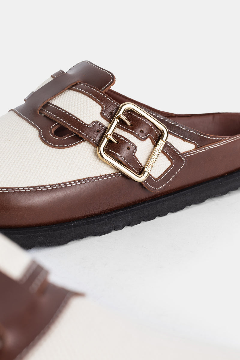 Birkenstock 1774 Boston uomo, dettaglio fibbia quadrata dorata su cinturino in pelle marrone e inserto in tela beige.