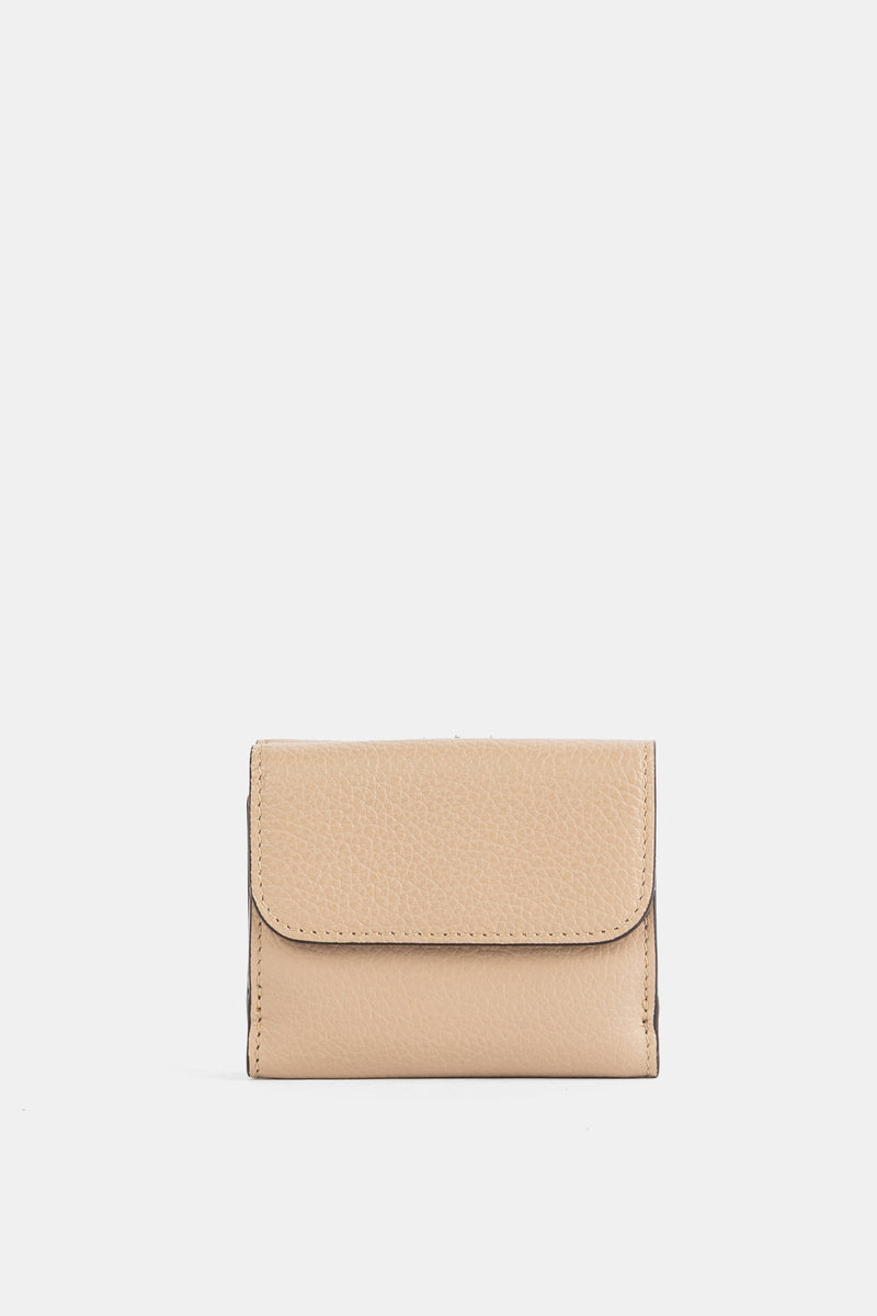 Mini carteira trifold para mulher Chloé em pele granulada beige areia com aba arredondada e costuras visíveis.