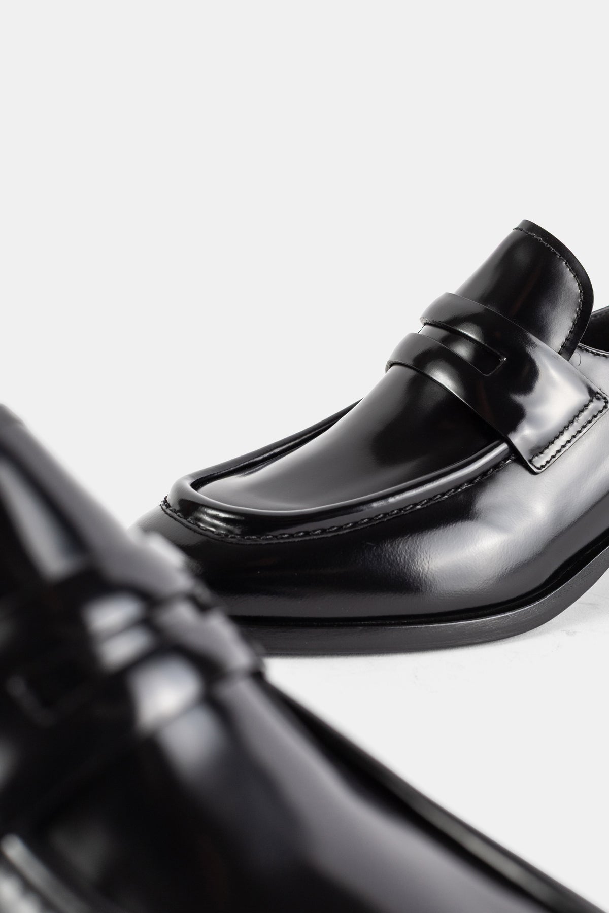 Church's Prudence loafers cuir veau poli noir, gros plan toe cap et surpiqûres en relief sur fond blanc épuré