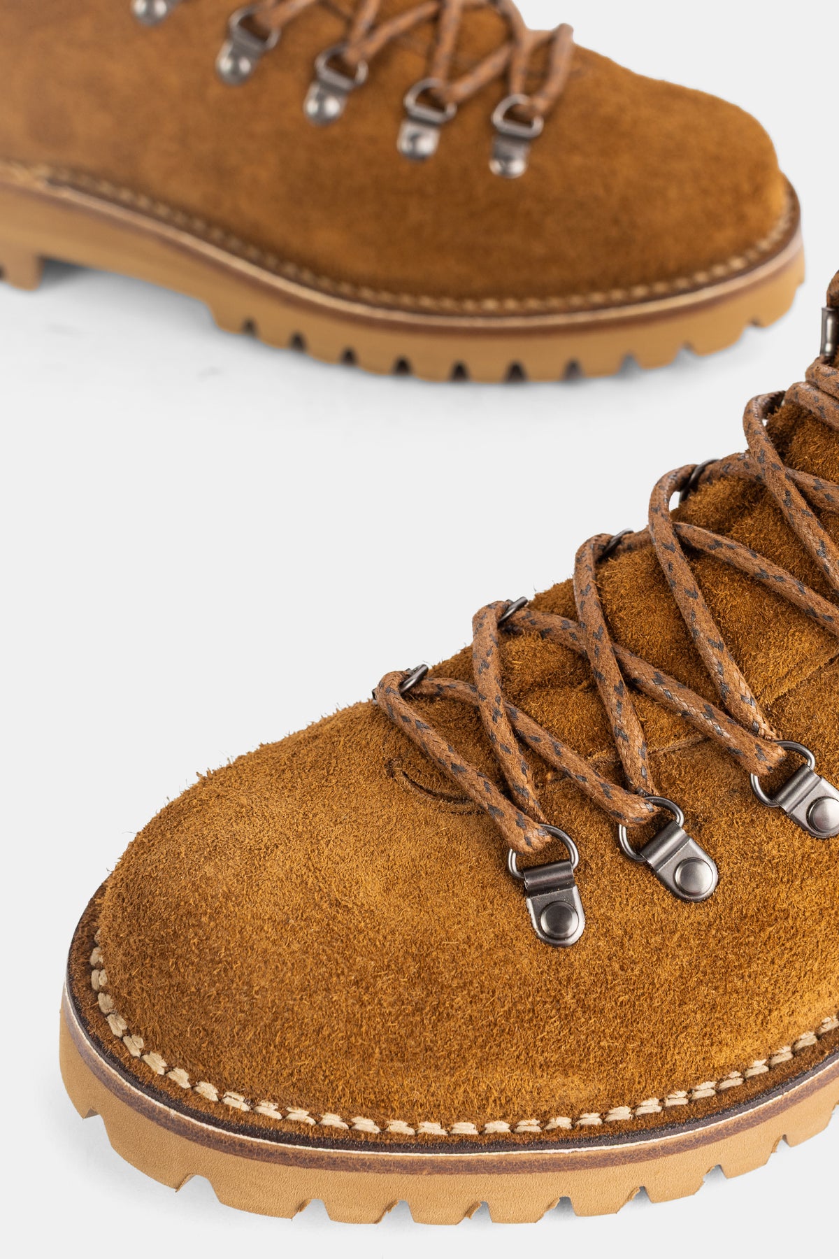 Church's men's lace-up boot, detail of saddle stitching on the honey suede upper and caramel lug sole.