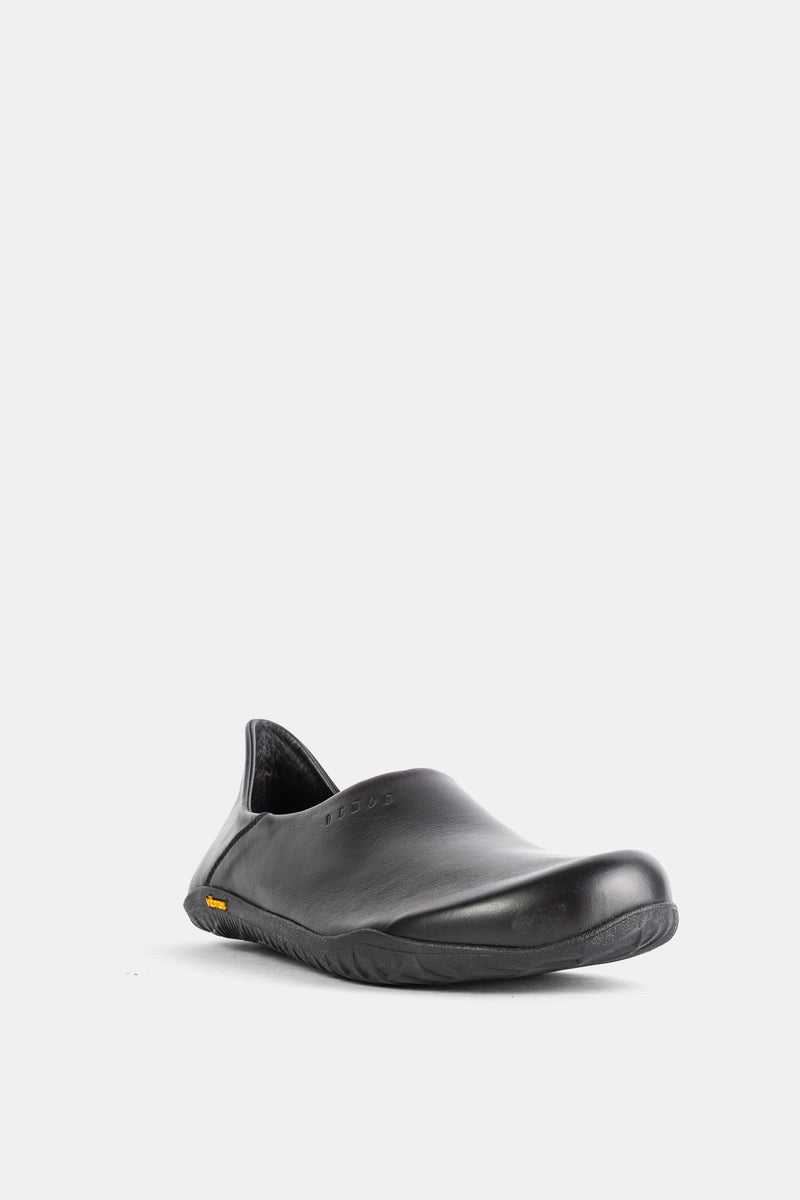 Three-quarter view of the Demon Dalmara black matte leather mule with a round toe and textured Vibram sole.