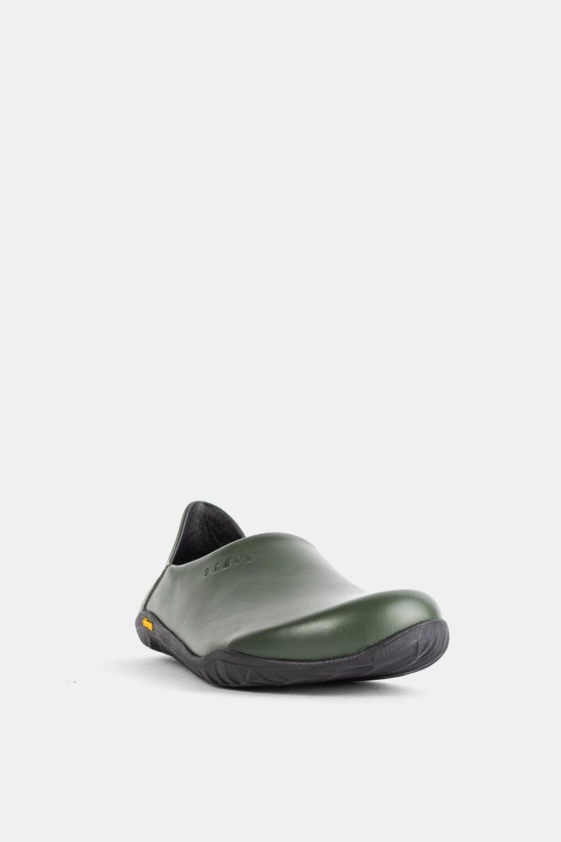 Unisex Demon Dalmara mule in khaki green leather, three-quarter front view showing black tongue.