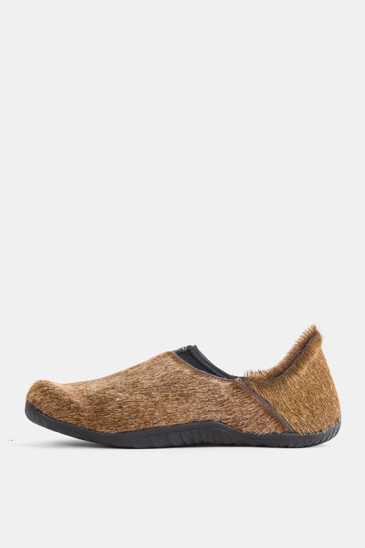 Perfil lateral da mule Demon Dalmara Fur Irish Coffee, gáspea em pelo castanho caramelo e sola Vibram preta perfilada.