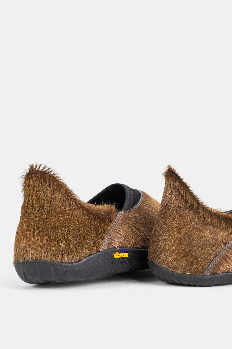 Vista traseira das mules Demon Dalmara Fur Irish Coffee, calcanhar em pelo castanho e logótipo Vibram amarelo em sola preta.