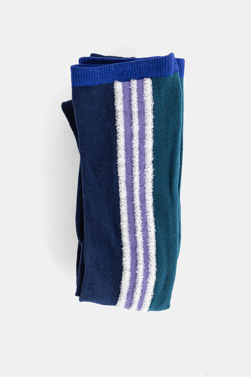 Meias altas dobradas tricolores Pleats Please Issey Miyake em azul-marinho, teal e faixa central violeta texturizada.