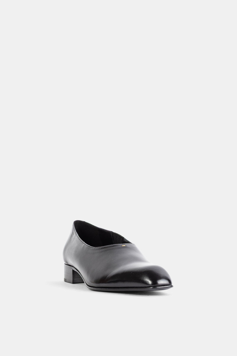 Khaite loafer Colt en cuir noir brillant, vue de face légèrement en angle révélant l'ouverture en V et détail doré