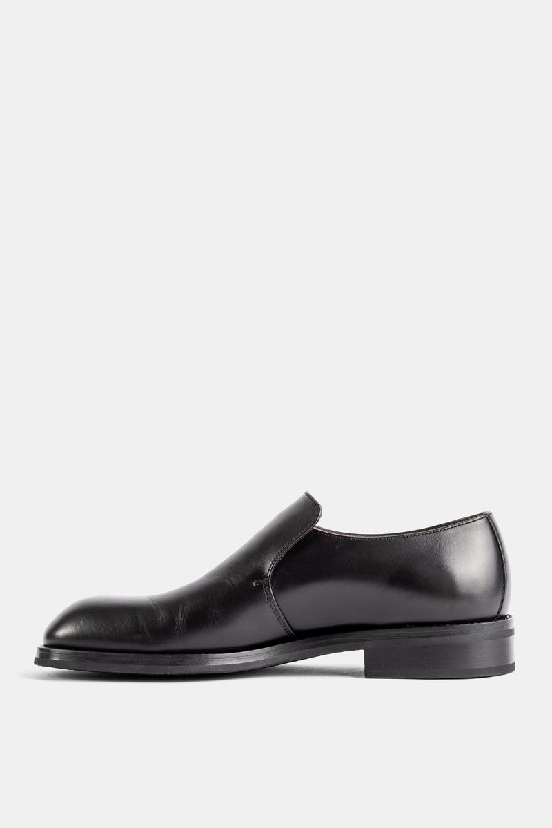 Lemaire slip-on formel cuir végétal noir brillant vue latérale gauche tige monobloc lisse semelle fine noire