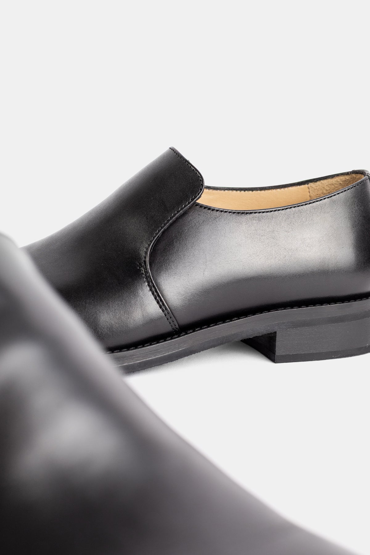 Lemaire slip-on cuir végétal noir zoom arrière chaussure détail couture intérieur beige doublure souple
