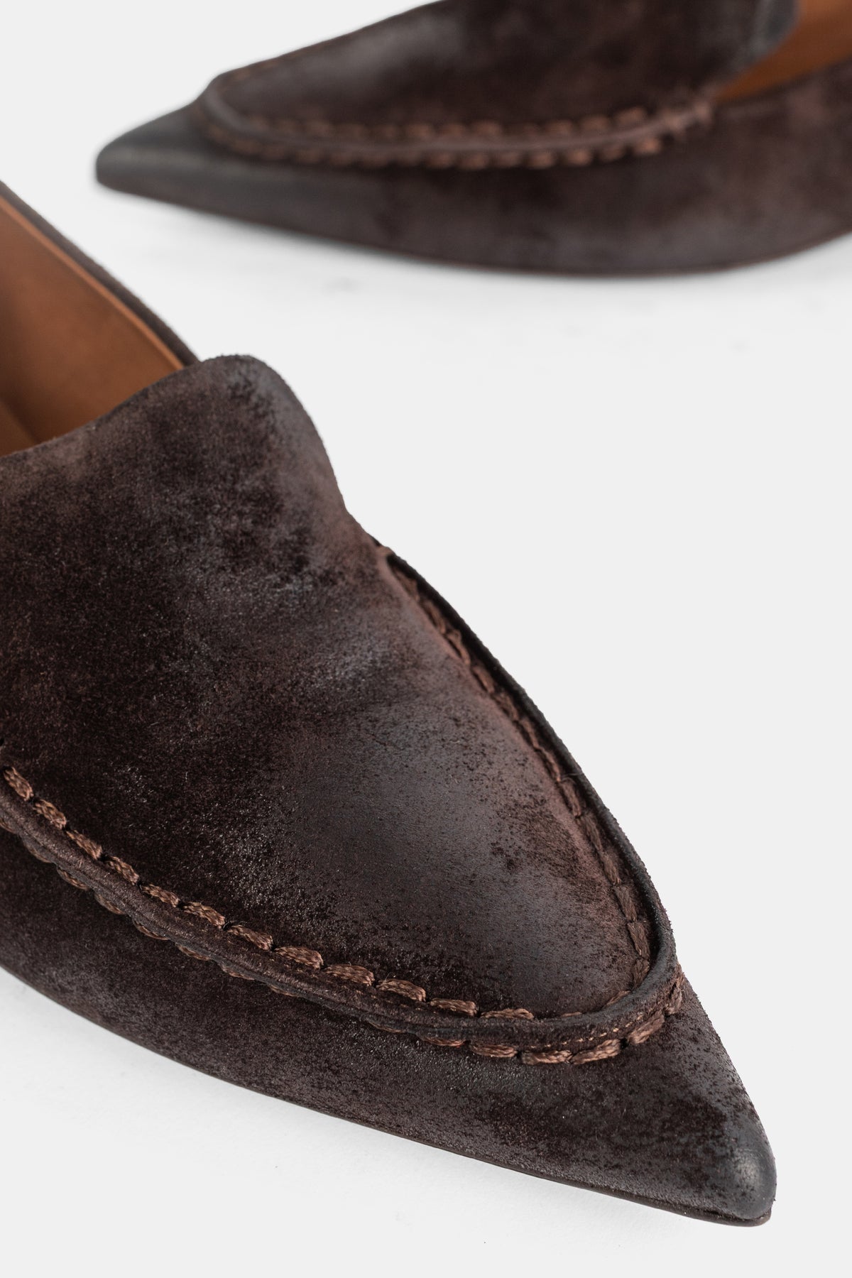 Nahaufnahme der handwerklichen Mokassin-Nähte und der spitzen Kappe des braunen Marsell Spino Slippers Damen.