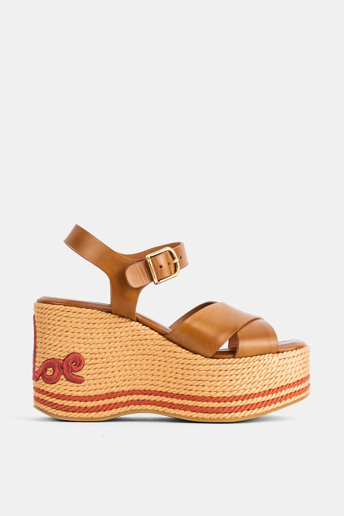 I sandali con zeppa Chloé Sand in pelle camel presentano listini incrociati e un plateau in rafia intrecciata.