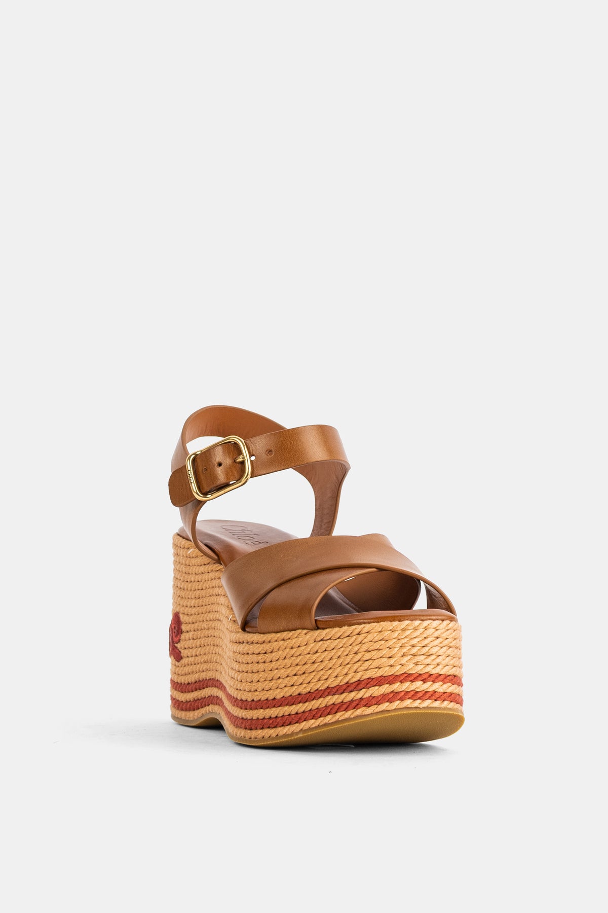 Sandali con zeppa da donna Chloé visti di fronte con suola in rafia, righe terracotta e fibbia dorata.