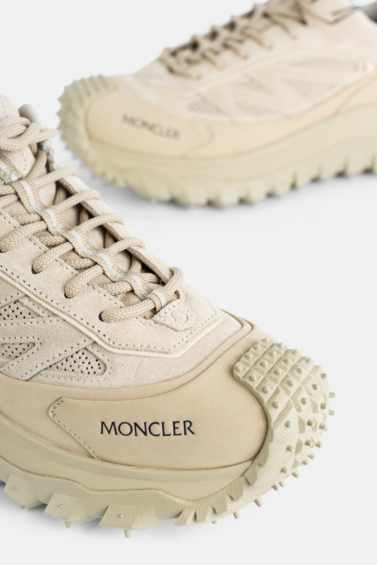 Grande plano da biqueira das sapatilhas Moncler Trailgrip Apex Craft GTX bege logótipo preto sola grip homem