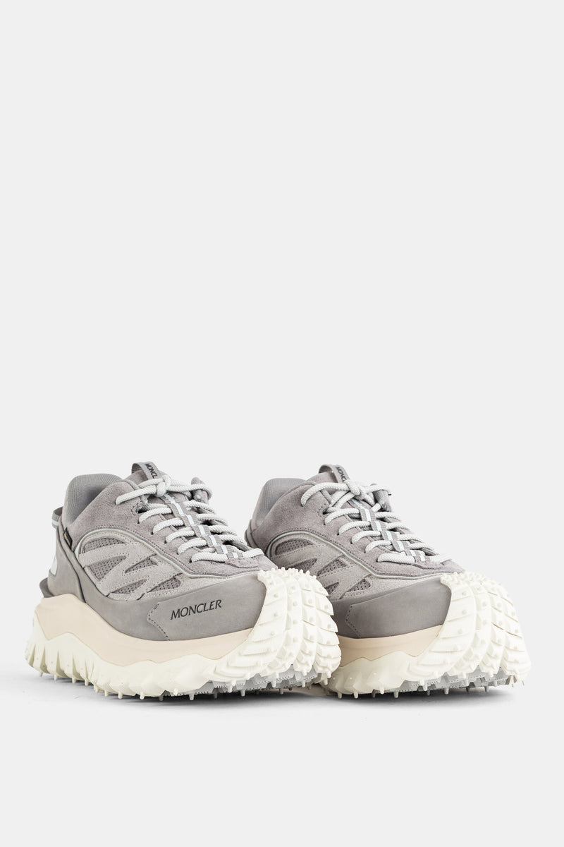 Ein Paar graue Moncler Trailgrip GTX Sneaker mit erhöhter weißer Spike-Sohle und sichtbarem Seitenlogo.