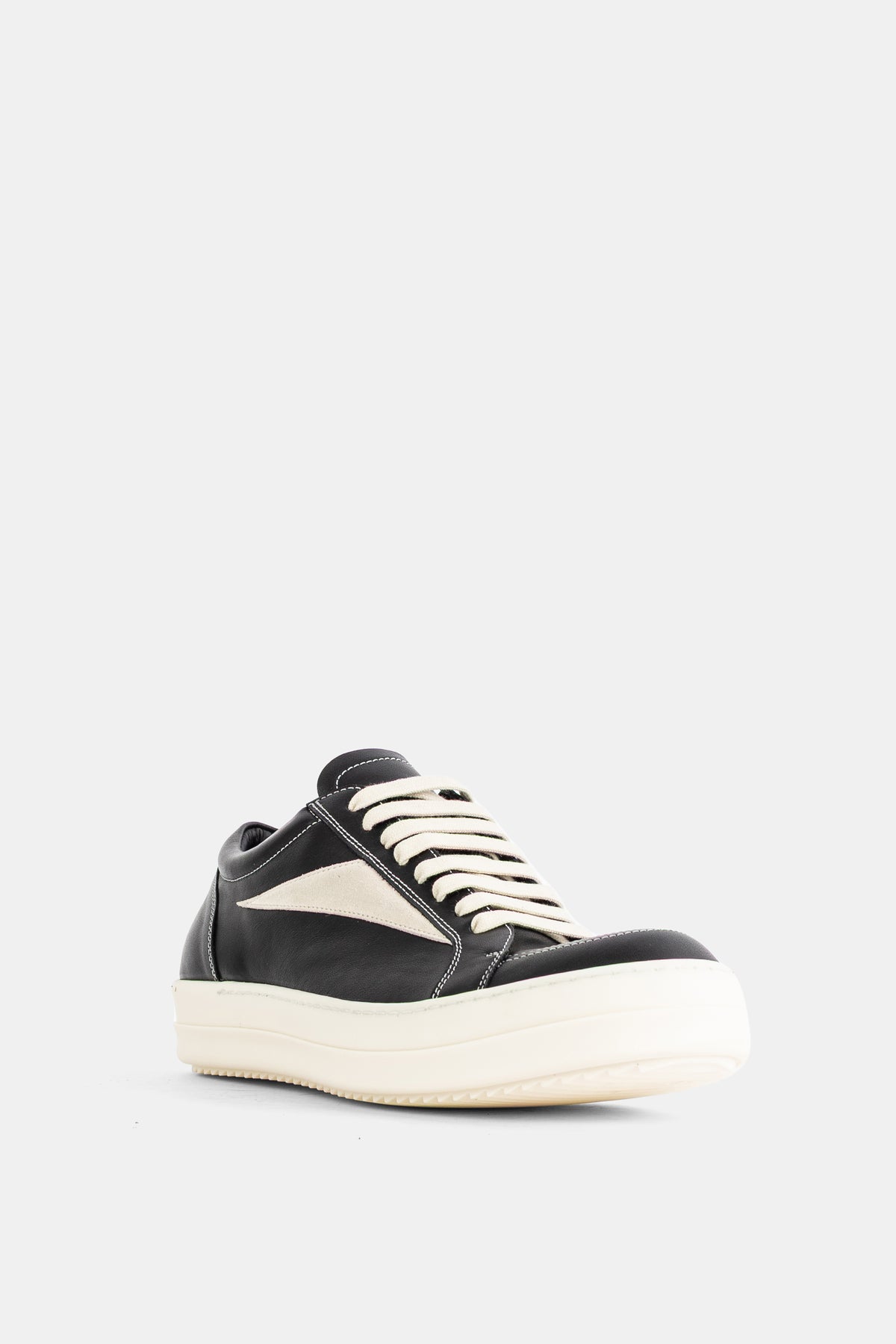 Rick Owens men's black leather sneakers with thick ecru laces and a chunky white platform sole, three-quarter view