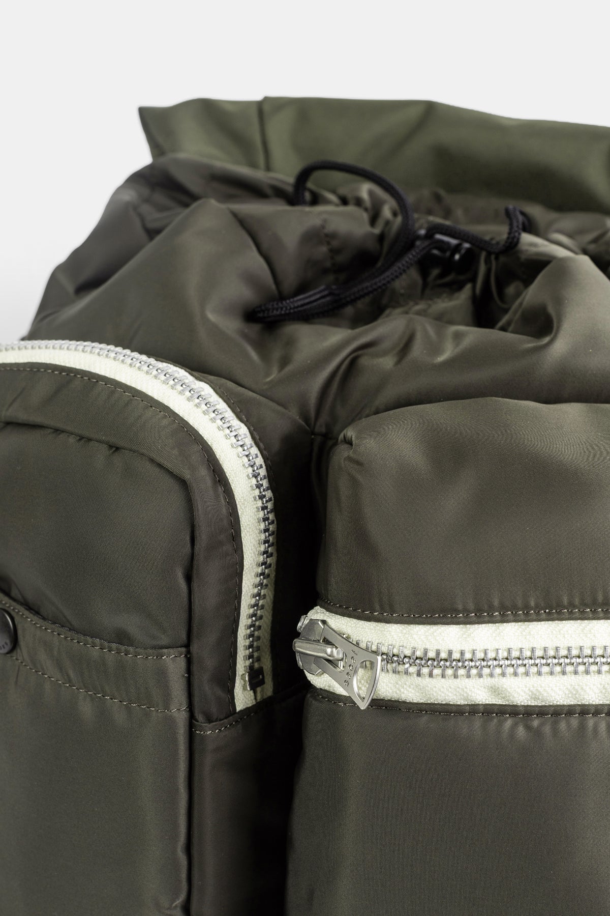 Sacai sac à dos Utility détail poches zippées kaki fermetures éclair bicolores crème et cordon de serrage noir