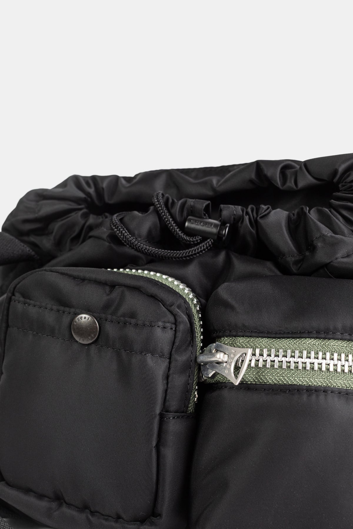 Sacai sac utility noir détail poche frontale zippée fermeture éclair kaki argentée et cordon coulissant