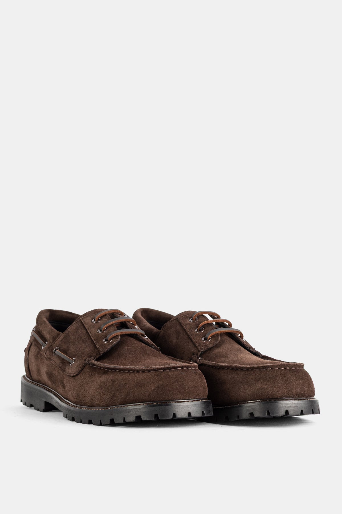 Studio Nicholson paire bateau suède brun profil avant couture moc-toe lacets contrastants semelle gomme noire