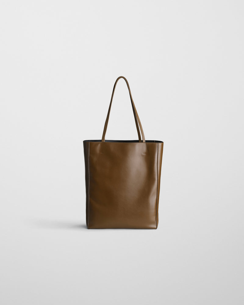 Phoebe Philo Paper Tote cuir bronze, face avant épurée, fond blanc, profil rectangulaire et anses rondes tendues