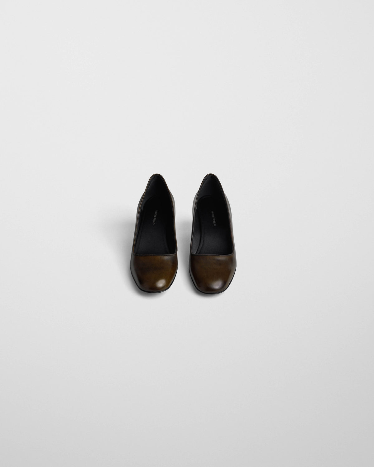 Bovenaanzicht van de Phoebe Philo Low Pump met zwarte binnenkant en gepatineerd donkerolijfkleurig leer.