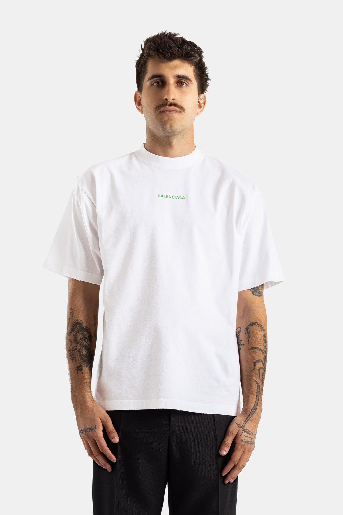 Witte oversized Balenciaga Back Fit T-shirt met ronde hals, korte mouwen en een groen gecentreerd logo.