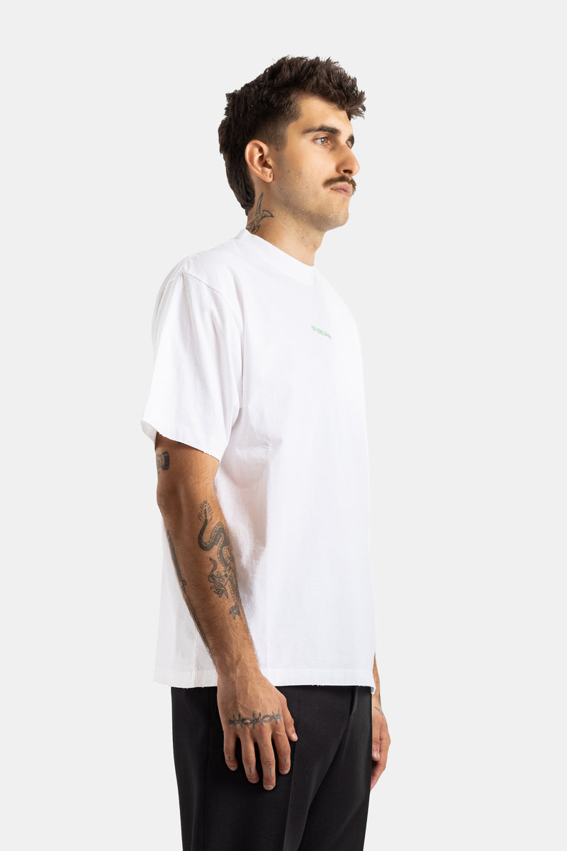 Balenciaga heren T-shirt in het wit, zijprofiel met zichtbare tatoeages, losse pasvorm en groen logo.