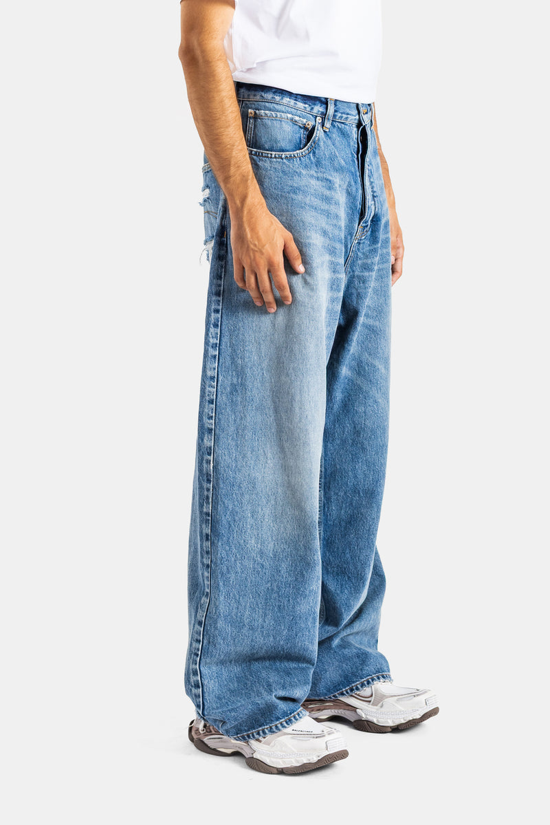 Balenciaga jean Round Fit homme profil latéral denim bleu avec effet usé et coupe baggy extra-large