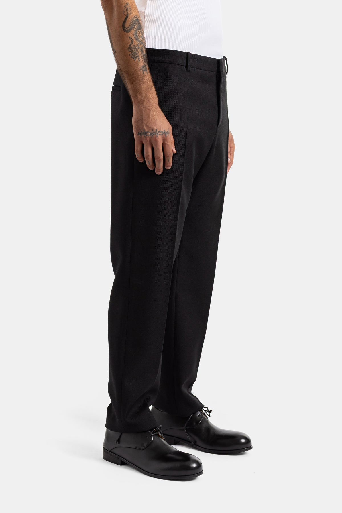 Balenciaga pantalon tailleur skinny laine noir homme, vue latérale avec crease et chaussures derby cuir
