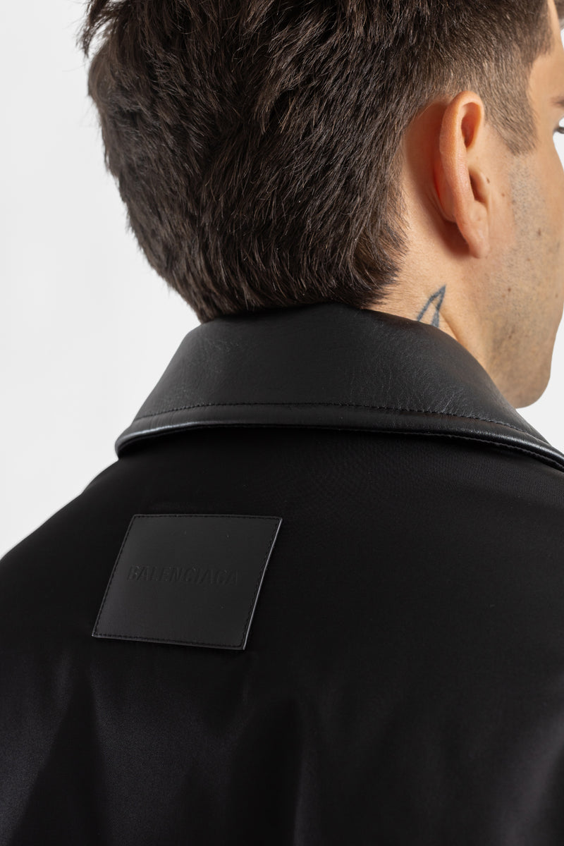 Vista de la nuca del bomber Balenciaga Cocoon negro con cuello de piel, parche de logo en relieve para hombre.