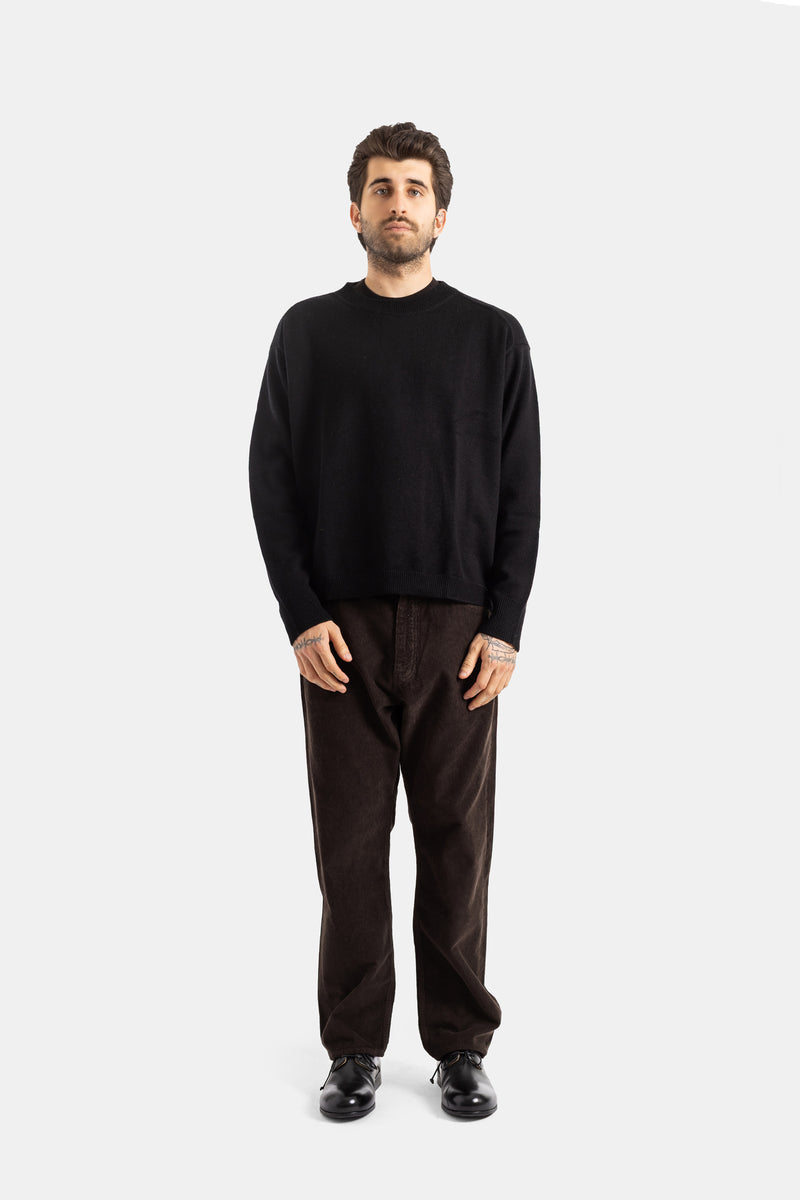 Studio Nicholson pull laine noire homme porté avec pantalon velours côtelé marron et derbies noirs