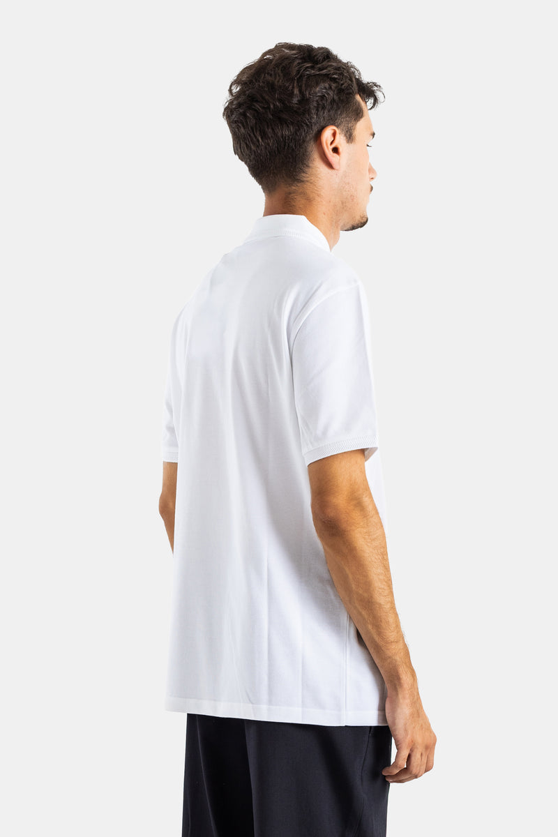 Back view of Moncler men's white cotton piqué polo, showcasing the loose fit and ribbed sleeve finishes.