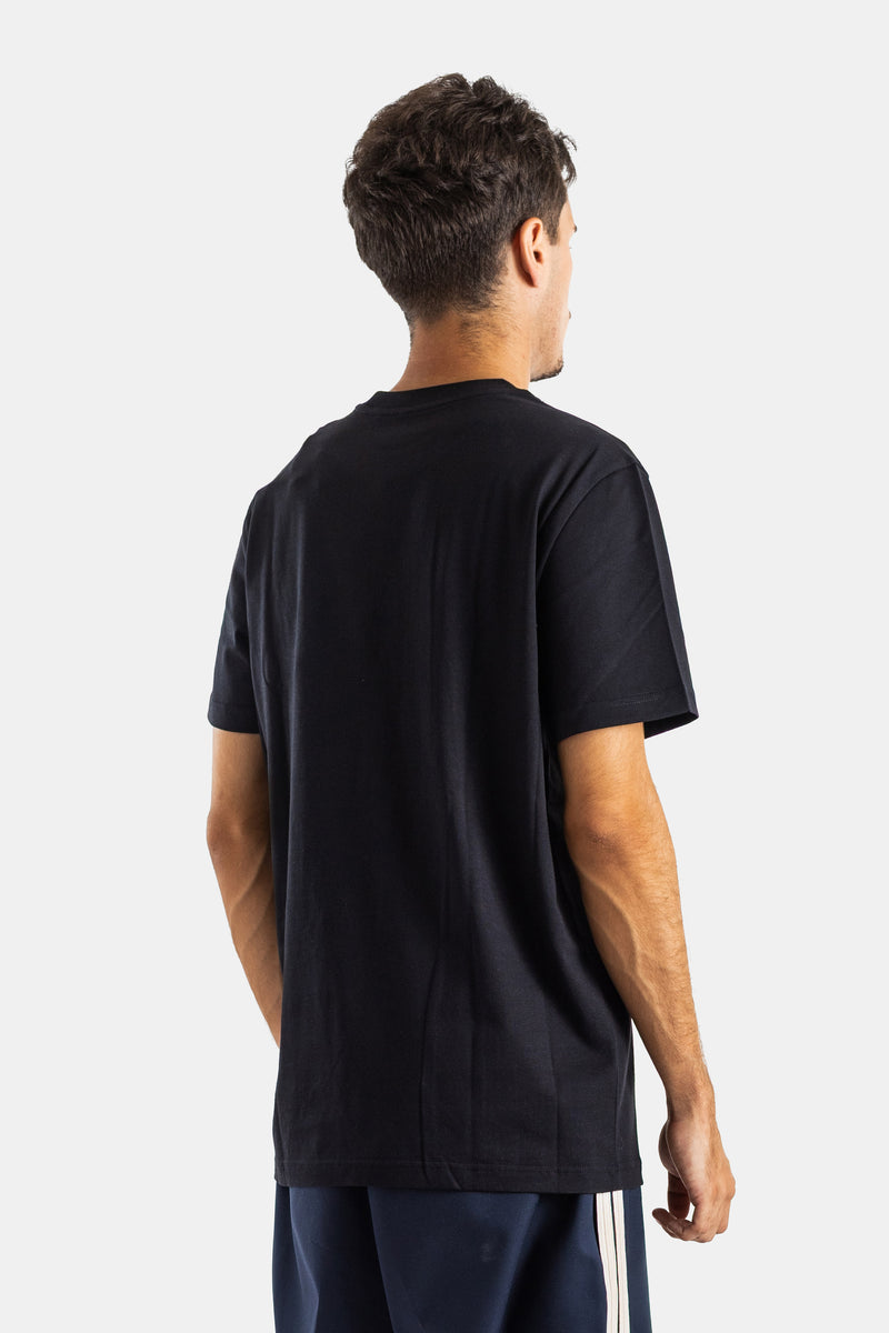 Rear view of Moncler men's straight cut black cotton t-shirt paired with striped navy blue track shorts