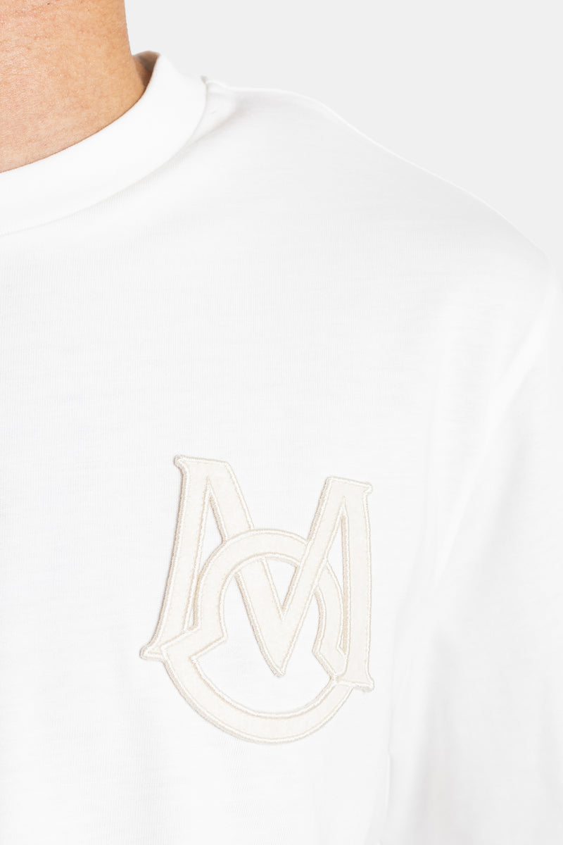 Close-up of Moncler men's white cotton T-shirt chest with embroidered tone-on-tone DM monogram and patch