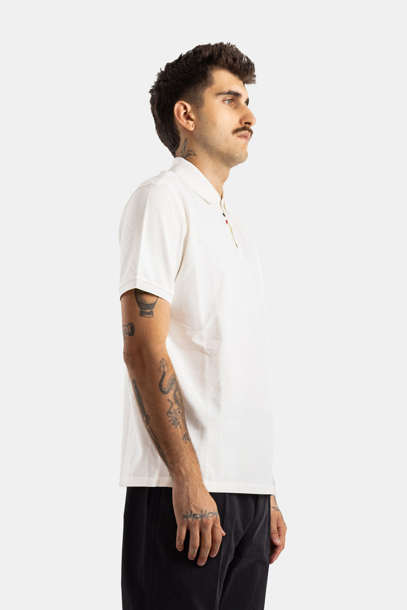 Moncler polo blanc homme profil tatouages bras vue latérale piqué coton texture fine détail liseré rouge bleu
