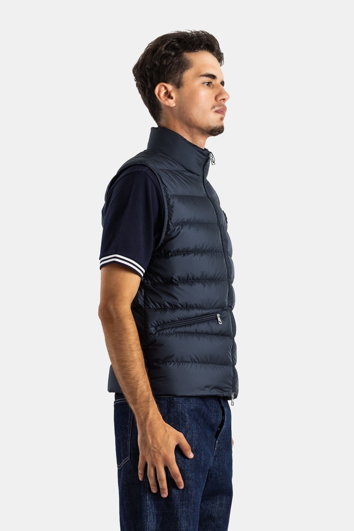 Profile view of the Moncler Treompan men's navy blue sleeveless down jacket with side zip and zipped pocket.