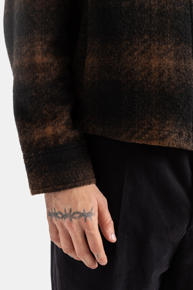 Moncler brown black plaid wool jacket, structured cuff and visible hand tattoo on the wrist of the man.
