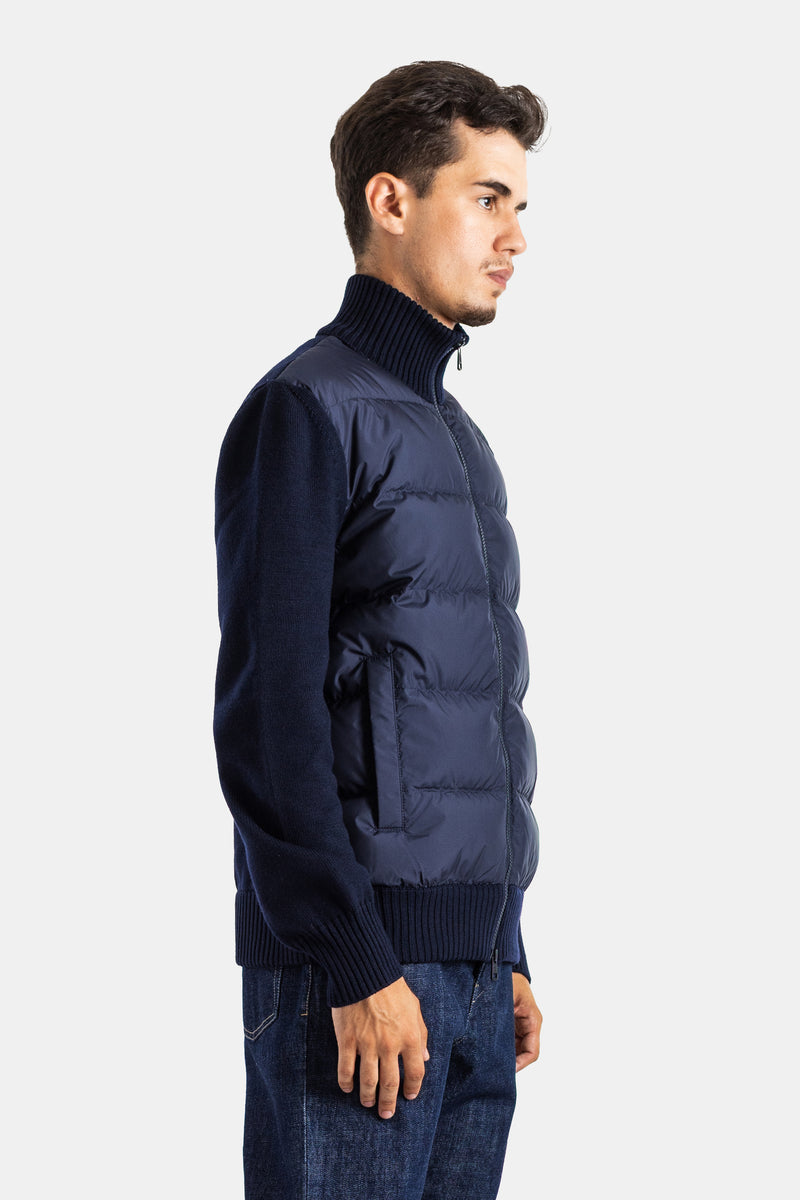 Profile view of Moncler men's navy blue hybrid quilted jacket featuring a zip closure and ribbed hem.