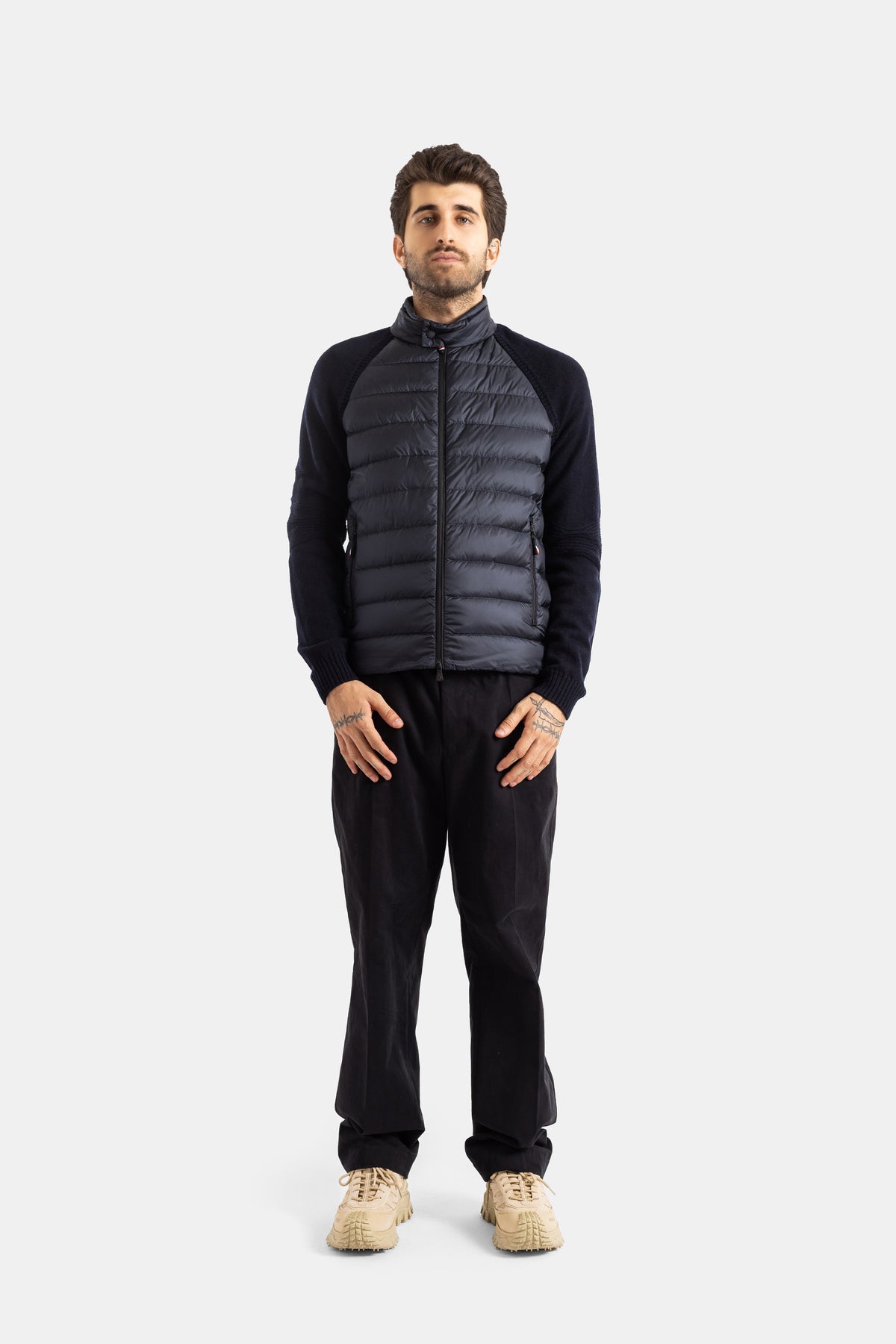 Moncler Grenoble homme look complet cardigan matelassé marine pantalon noir sneakers beiges vue frontale