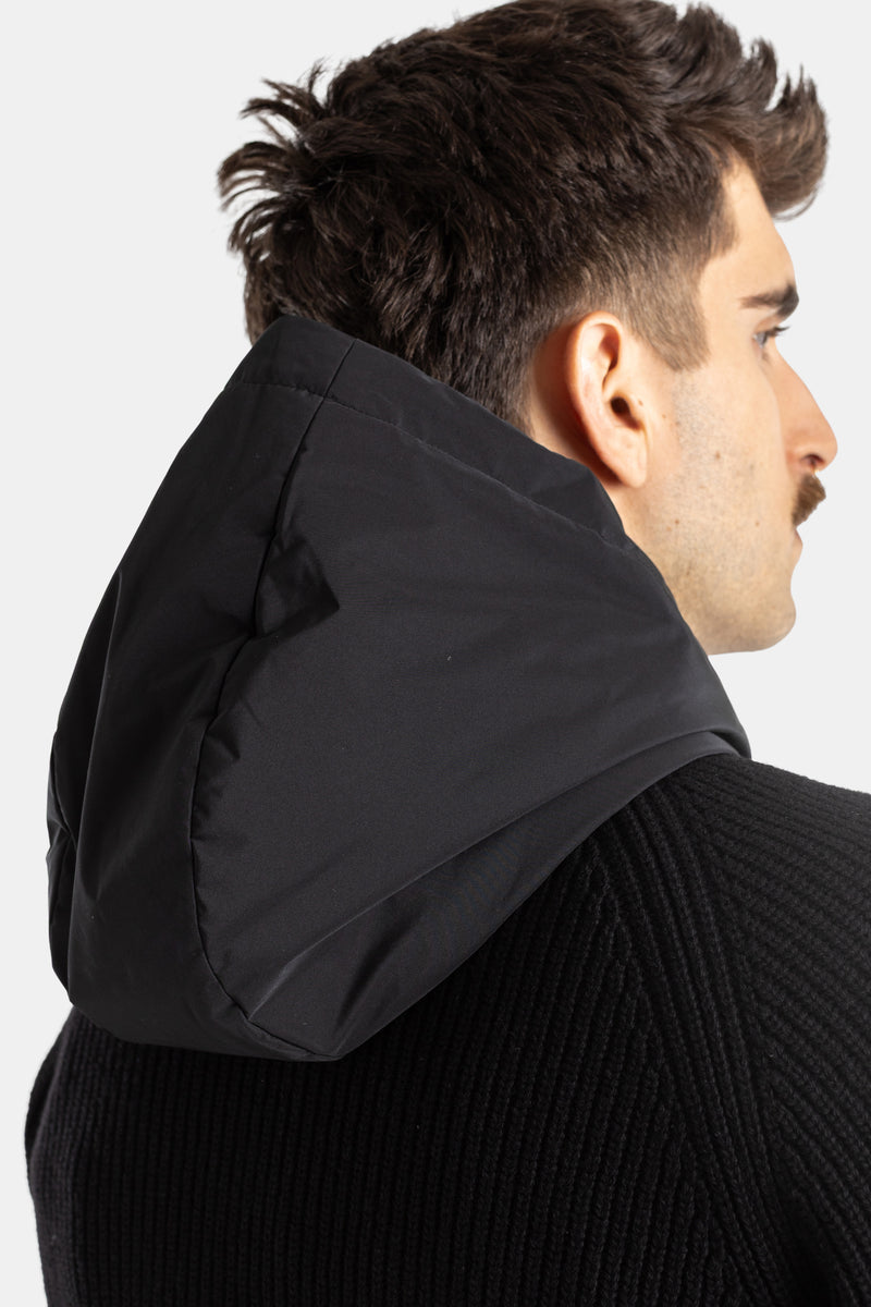 Three-quarter detail view of Moncler men's black quilted nylon hood over a ribbed knit collar cardigan.