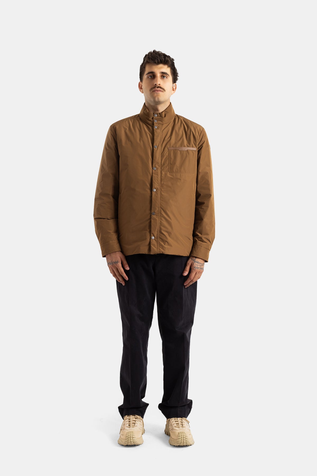 Moncler Yndale veste matelassée camel portée face entière avec pantalon noir et sneakers beige