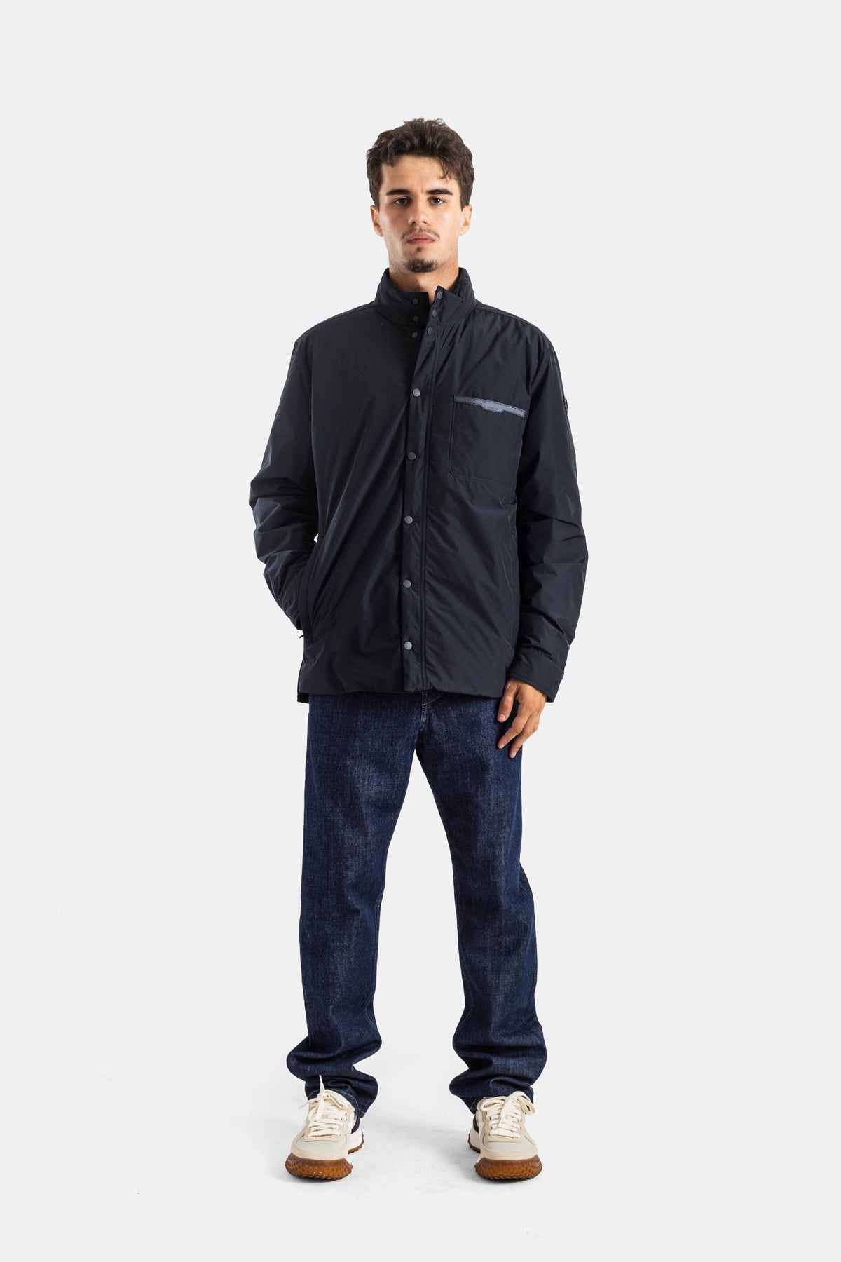 Blusão Moncler Yndale preto de homem, look completo com jeans brutos, sapatilhas brancas e pormenor no bolso.